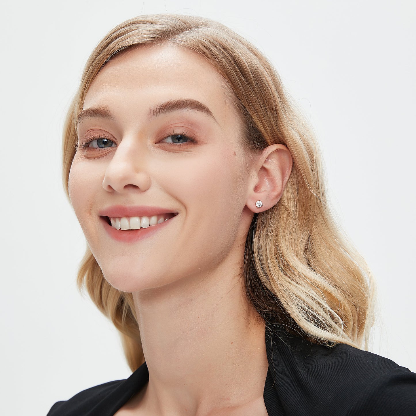 Woman with blonde hair smiling on a white background