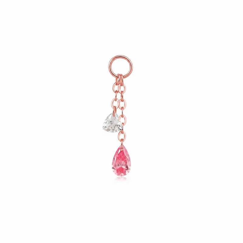A high-resolution studio photograph of the Pink Pear White Heart Charm from LTM Jewels. This 18K solid gold charm features a unique kinetic design with a laser-drilled 0.10ct white heart-cut diamond paired with a swaying 0.20ct pink pear-shaped lab-grown diamond. The image captures the crystalline purity of the D-E color heart and the delicate rose hues of the pink pear, showcasing the VVS-VS clarity and master craftsmanship of the AU750 gold setting.