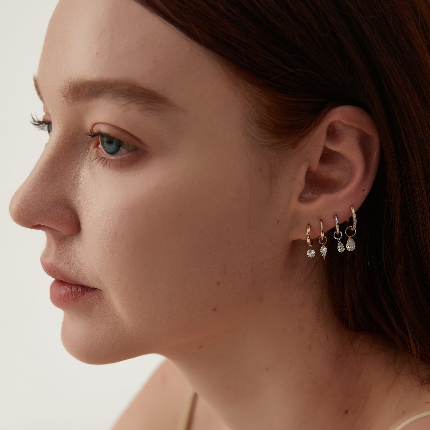 Close-up of a woman wearing earrings with a plain background