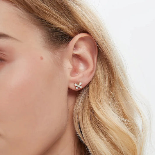 The LTM & CO.™ 18K Gold Marquise Butterfly Diamond Stud Earring worn on an earlobe. The brilliant white diamond butterfly appears poised for flight, adding a touch of whimsical elegance to the ear. Demonstrates the perfect scale for daily wear and the radiant sparkle against skin. Single earring styling.