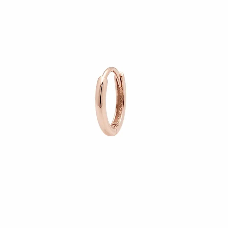 This primary product image showcases the Essential Gold Hoop from the Radiant Drift collection by LTM & CO., presented in a pristine, high-contrast setting to emphasize its sculptural form. Meticulously handcrafted from 18K solid gold (Au750), the hoop features a radiant, high-polish finish that reflects a warm, luxurious glow. A hallmark of the Radiant Drift series, the design integrates ethically sourced lab-grown diamonds that appear to be in a state of graceful, fluid suspension along the golden curve.