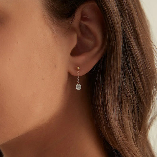 Macro close-up of the Round Chain Dangle Threaded Stud handcrafted in solid 18K gold. The suspended floating round diamond and delicate gold chain create uninterrupted brilliance, fluid movement, and refined architectural craftsmanship inspired by contemporary fine jewelry design.