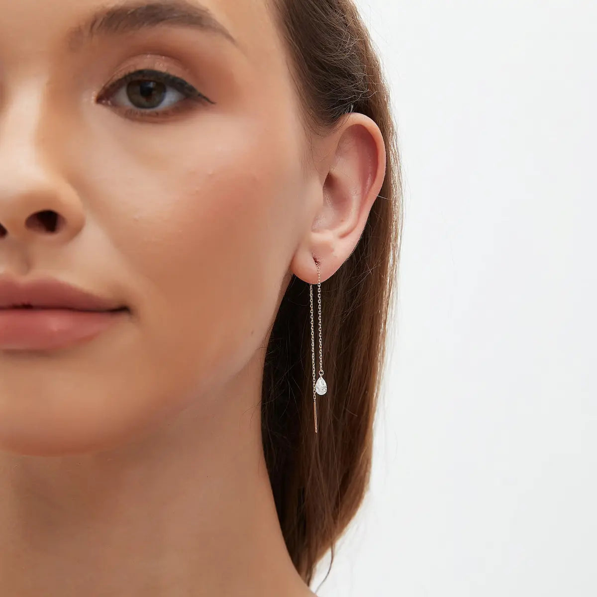 Side profile view of the pear-cut diamond threader earring, focusing on the smooth, comfortable 18K gold chain and the slim, minimalist profile of the diamond drop. This perspective highlights the adjustable nature of threaders, allowing for a custom fit in the lobe or cartilage. The image confirms the sturdy yet delicate construction of the solid gold chain, ensuring it is snag-free and comfortable for side sleepers or 24/7 permanent wear.