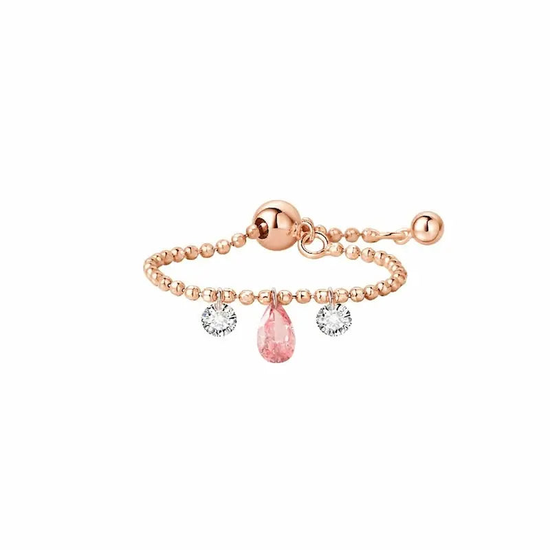 A high-resolution studio photograph of the Trio Diamond Pink Pear White Round Chain Ring from the LTM Jewels Radiant Drift collection. Handcrafted in 18K solid gold, the ring features a 0.13ct fancy pink pear diamond centerpiece flanked by two 0.08ct brilliant white round diamonds on a flexible chain band. The image highlights the high-polish AU750 gold finish and the exceptional fire of the 0.29ctw diamonds against a professional clean background.
