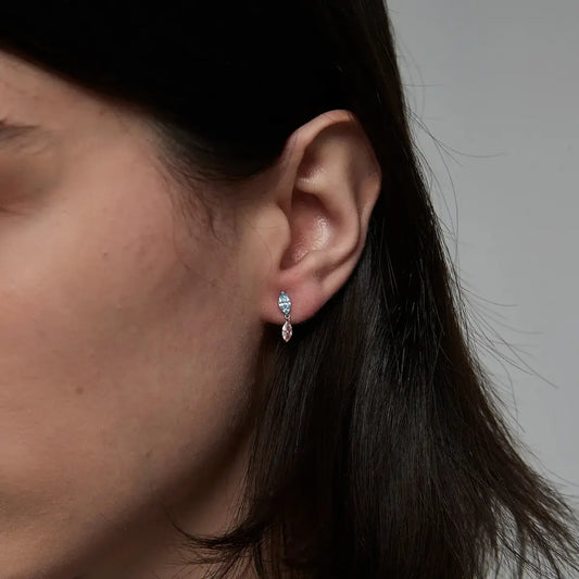 Macro close-up of the Blue and Pink Marquise Dangle Stud handcrafted in solid 18K gold. The suspended floating blue and pink marquise-cut diamonds create uninterrupted brilliance, fluid architectural movement, and refined contemporary fine jewelry craftsmanship.