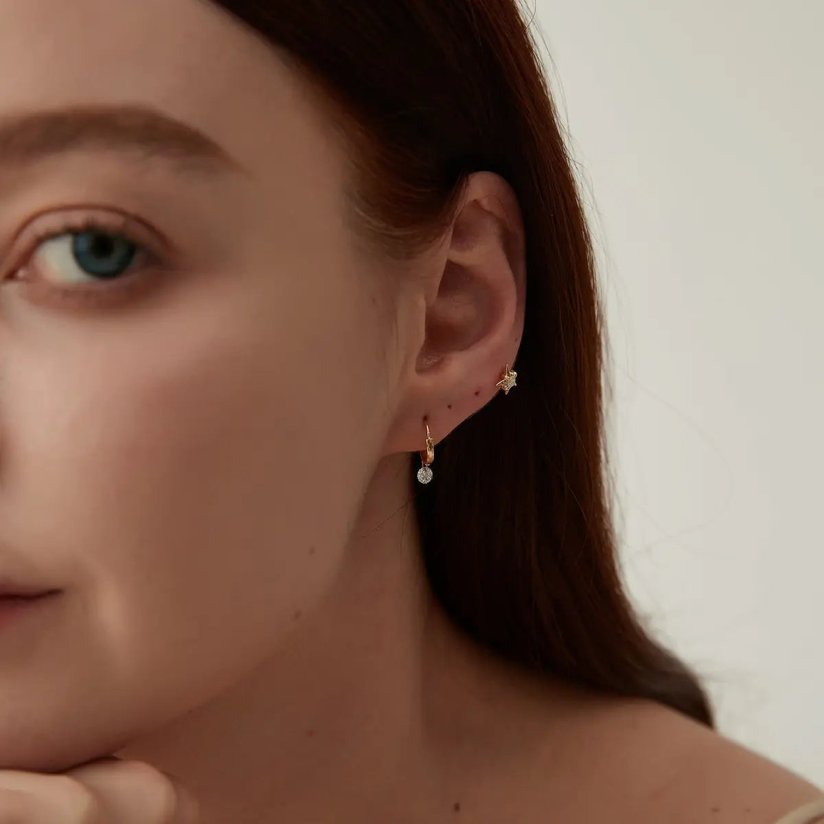 Side view of the Round Diamond Dangle Hoop crafted in solid 18K gold showcasing the secure click-to-close hinged mechanism and floating diamond construction. The lightweight sculptural hoop design is engineered for comfortable daily wear and refined contemporary styling.