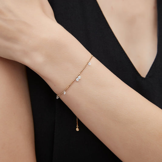 Close-up of seven 0.1ct drilled lab diamonds on a faceted gold bead chain.