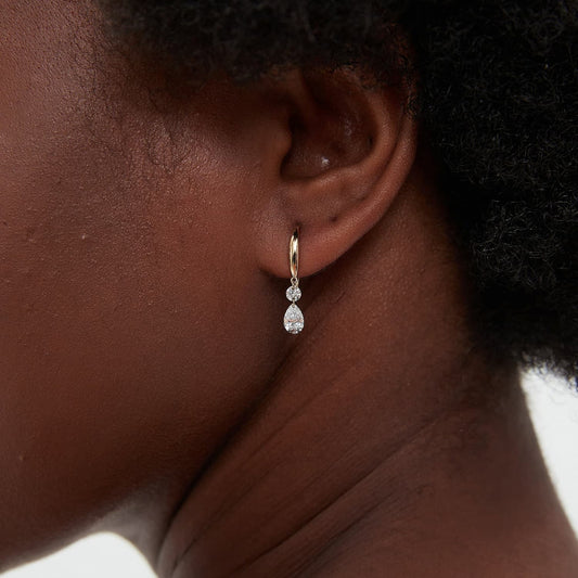 A macro close-up highlighting the pairing of the 0.1ct round and 0.3ct pear lab-grown diamonds. Focuses on the architectural setting, the D-E color fire, and the master craftsmanship of the 18K AU750 gold stud.