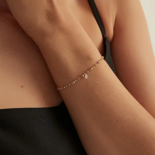 Close-up of the Floating Pear Diamond Bracelet showcasing a brilliant 0.15ct lab grown pear diamond suspended in LTM Jewels' signature laser-drilled floating setting. The polished 18K solid gold bead chain highlights exceptional craftsmanship, clean lines, and the diamond's brilliant sparkle.