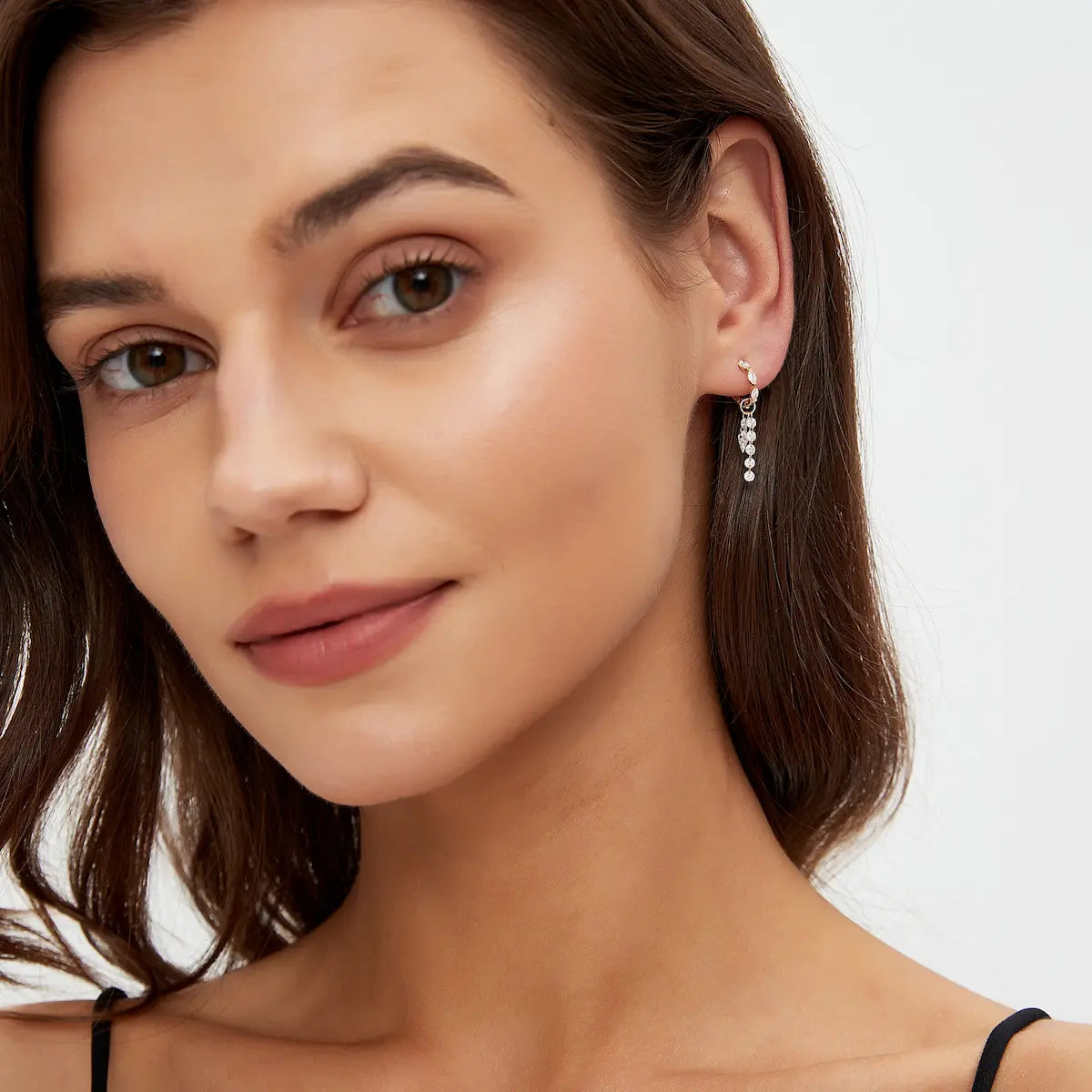 Asymmetric kite and round diamond connecting charm styled on a hoop earring creating fluid movement and luminous sparkle. The dual suspended diamond strands add architectural elegance and cinematic brilliance to curated ear styling while maintaining lightweight modern luxury aesthetics.