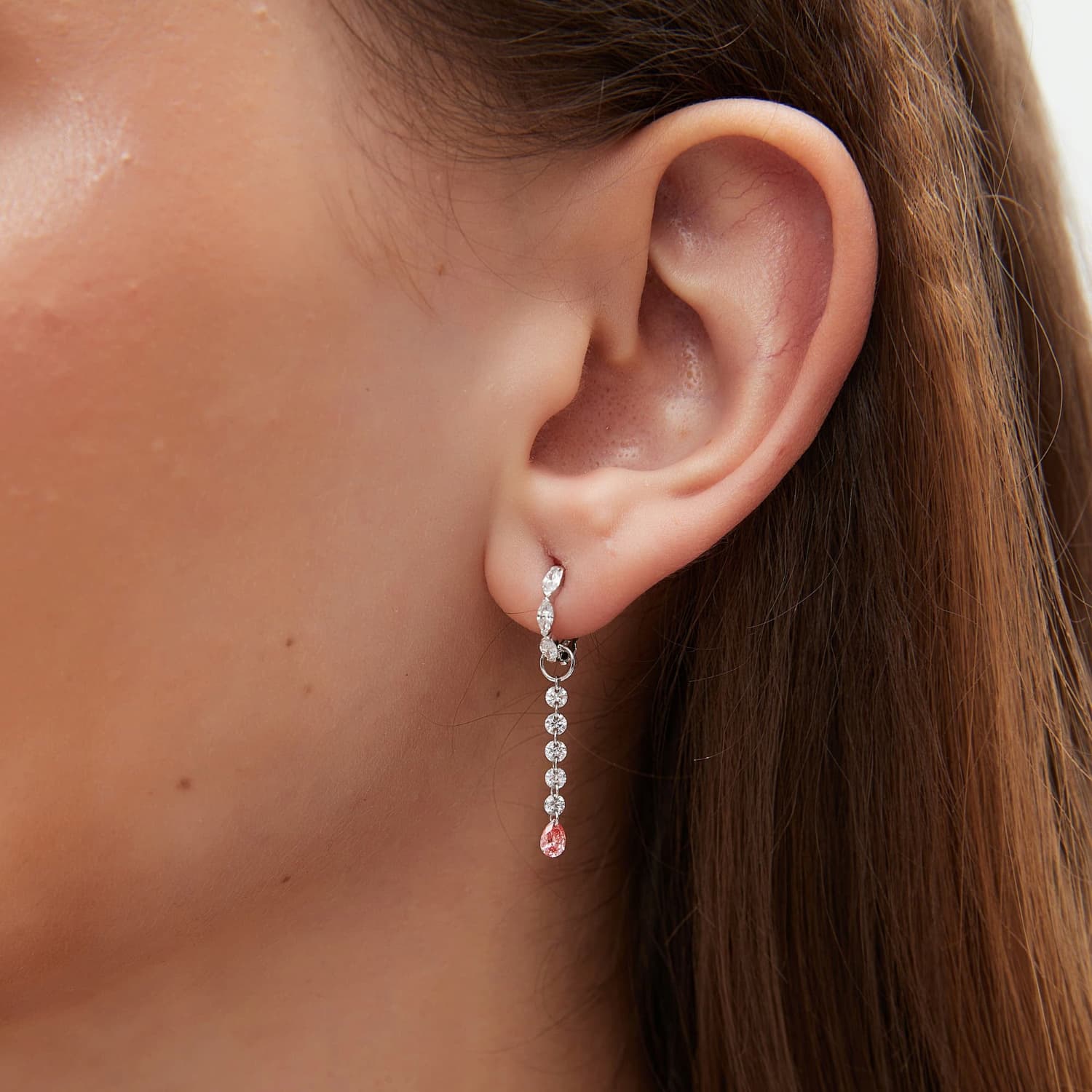 A detailed macro close-up focusing on the shimmering white diamond arc and the rare blush-colored pear-shaped diamond. The photograph reveals the exceptional VVS-VS clarity of the 0.20ctw stones and the precision of the handcrafted 18K gold link. It highlights the delicate contrast between the crystalline purity of the white accents and the captivating pink hue, illustrating the high-end artistry of the LTM Jewels Radiant Drift collection.