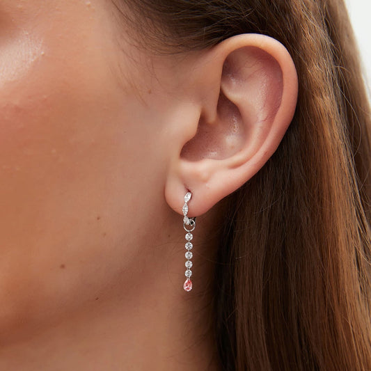 A detailed macro close-up focusing on the shimmering white diamond arc and the rare blush-colored pear-shaped diamond. The photograph reveals the exceptional VVS-VS clarity of the 0.20ctw stones and the precision of the handcrafted 18K gold link. It highlights the delicate contrast between the crystalline purity of the white accents and the captivating pink hue, illustrating the high-end artistry of the LTM Jewels Radiant Drift collection.
