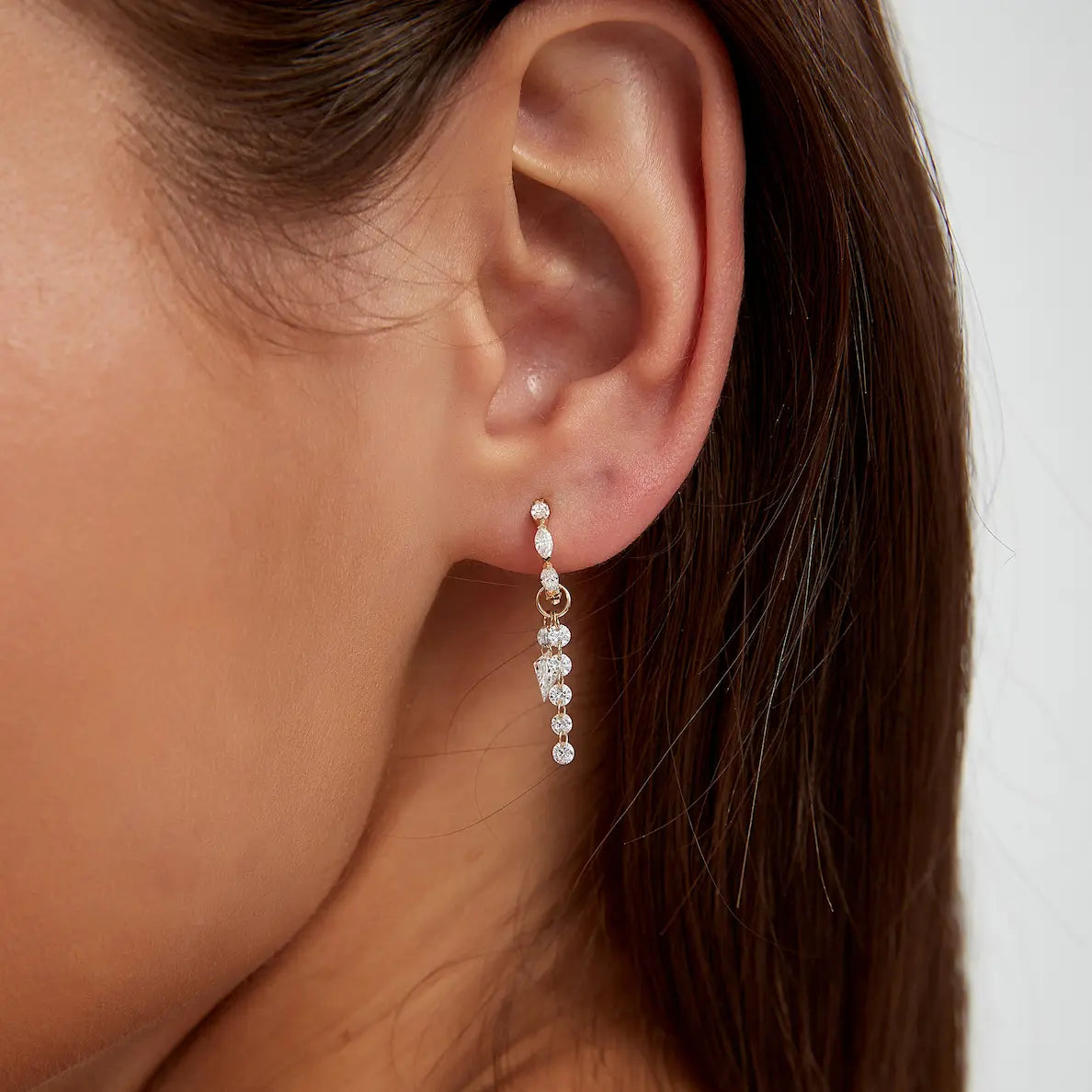 Macro close-up of the asymmetric kite and round diamond connecting charm handcrafted in solid 18K gold. The precision laser-drilled floating construction highlights uninterrupted brilliance, geometric symmetry, and the sculptural minimalist luxury aesthetic characteristic of the Celestial Drift collection.