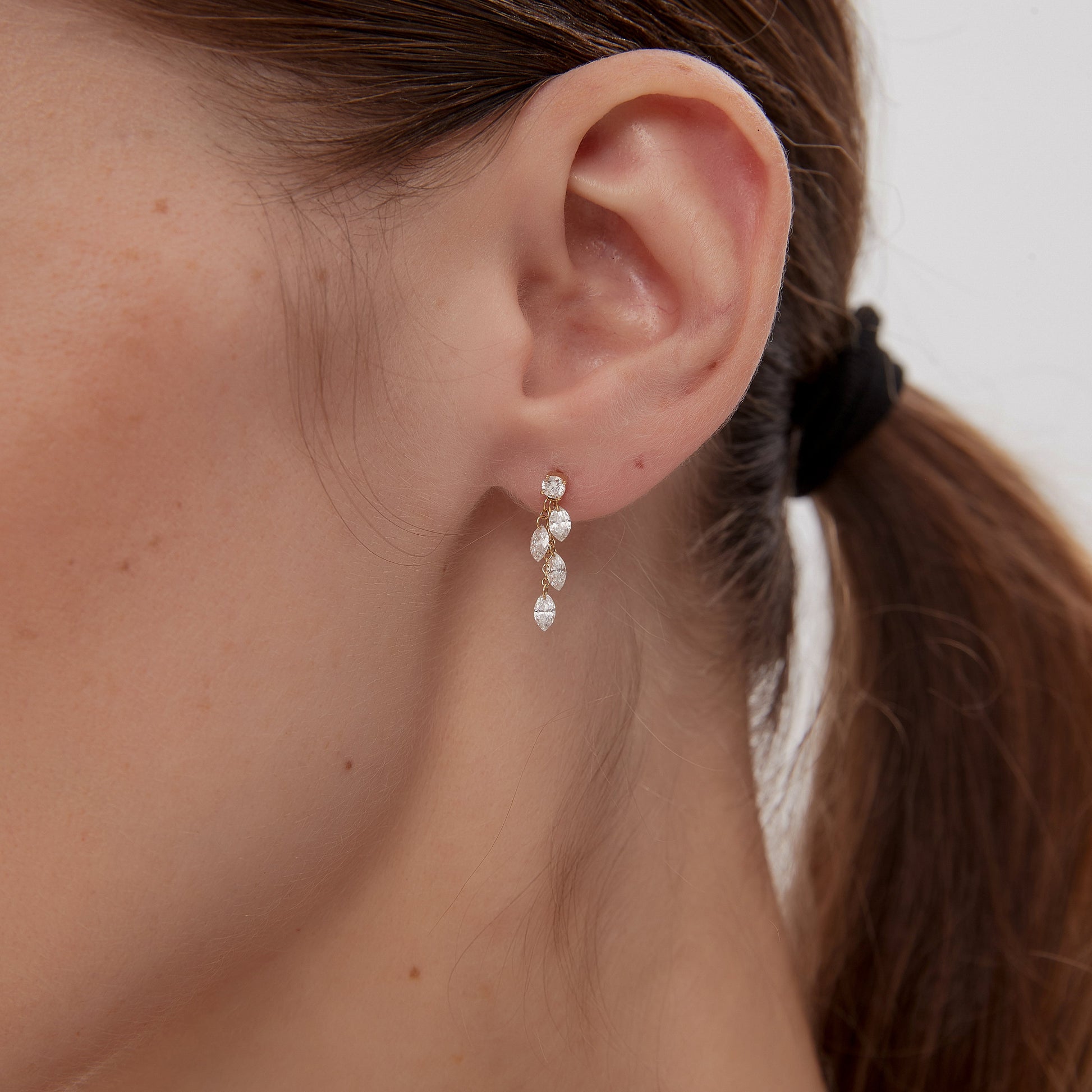 Close-up of an ear wearing a pearl earring with a blurred background