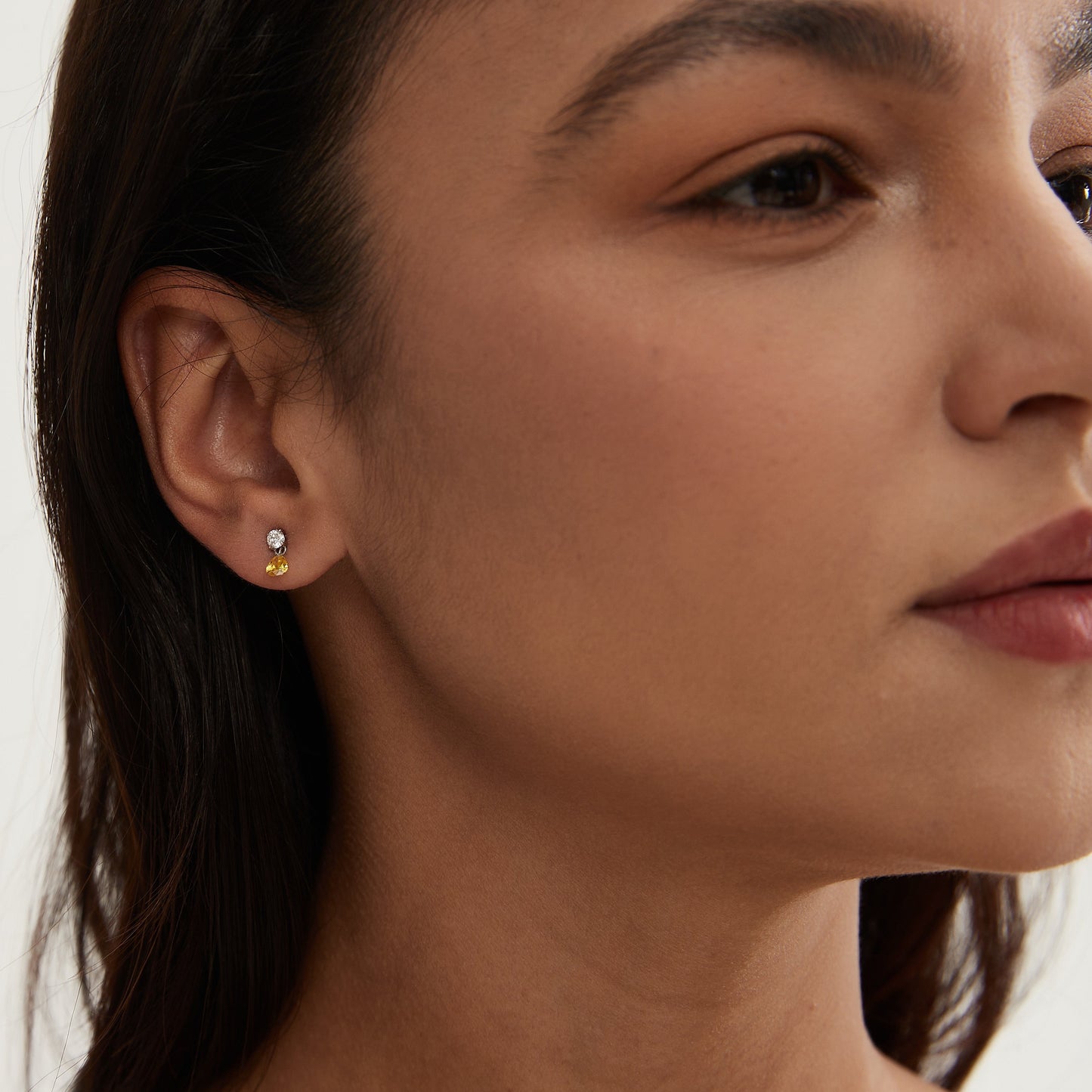 Single floating yellow marquise diamond threaded stud earring worn on ear