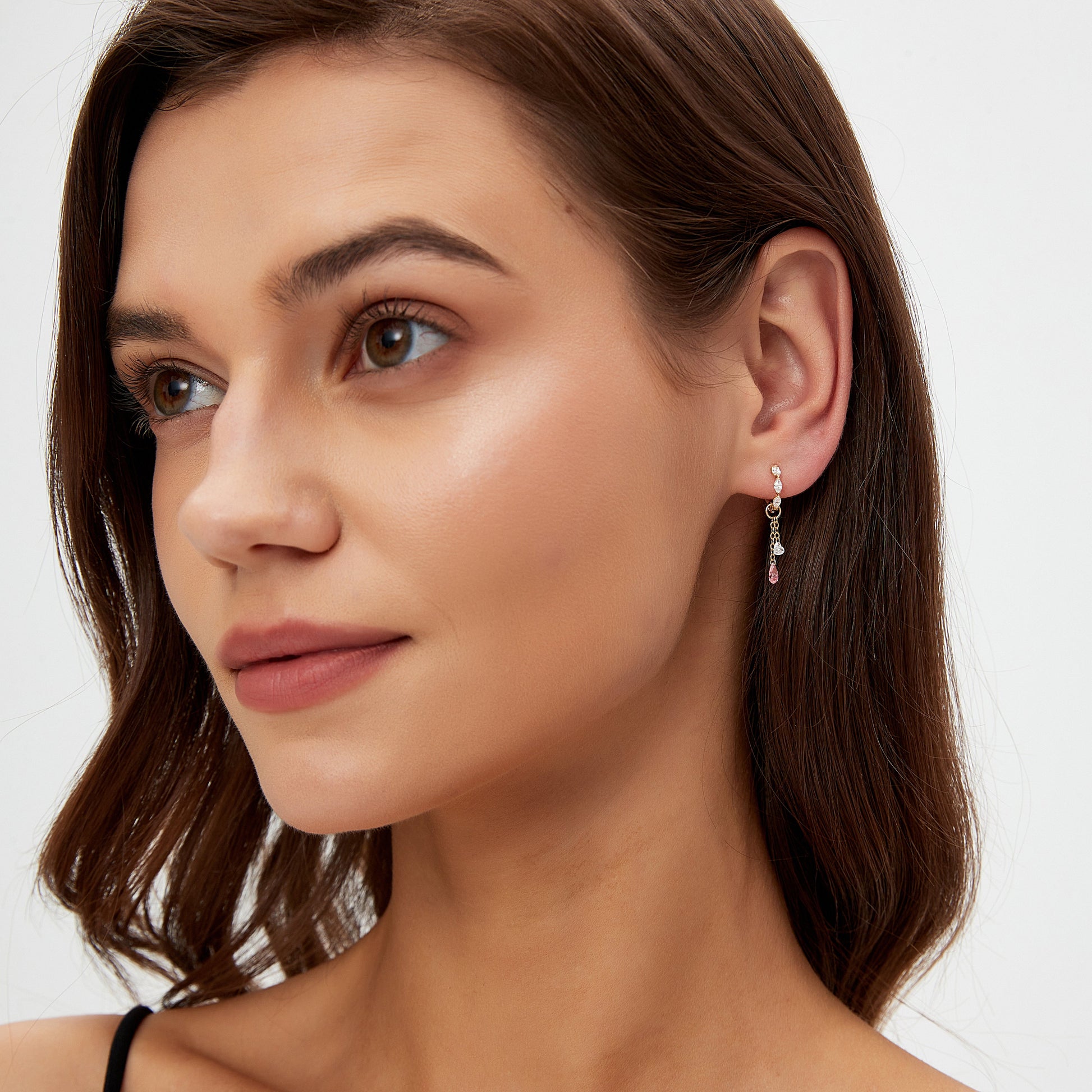 Close-up of a woman wearing a silver earring on a white background