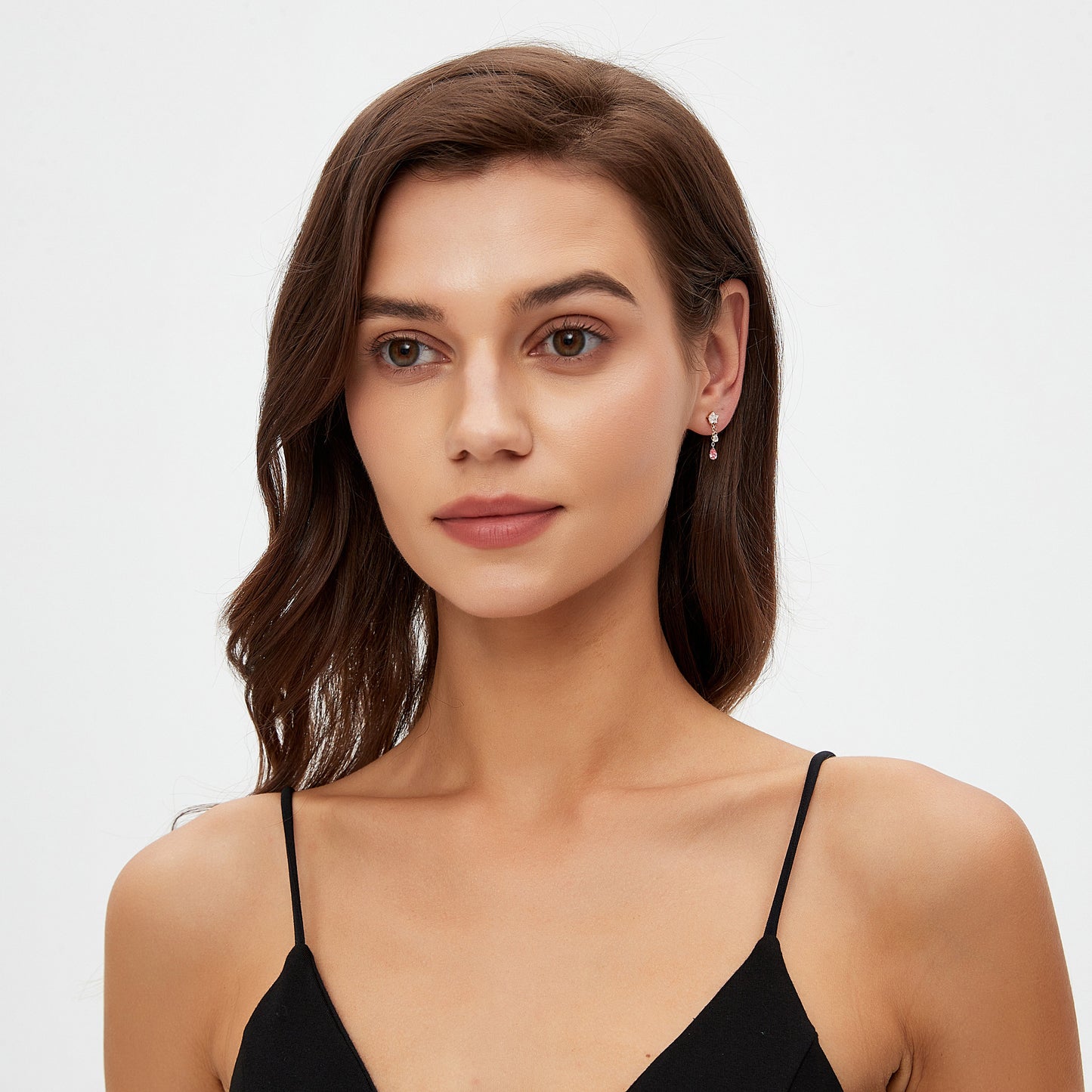 Woman wearing a black strappy top against a plain background