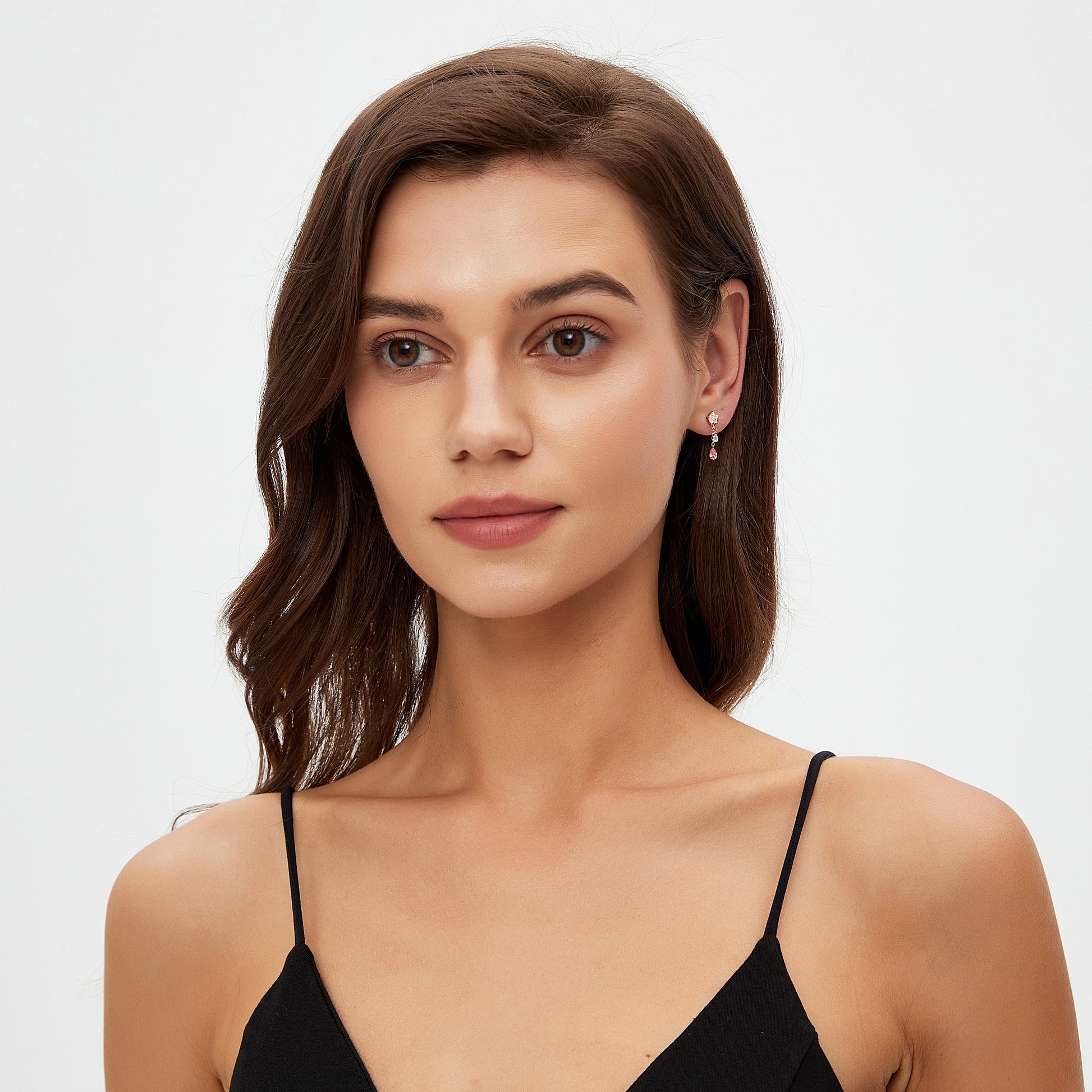 Woman wearing a black strappy top against a plain background