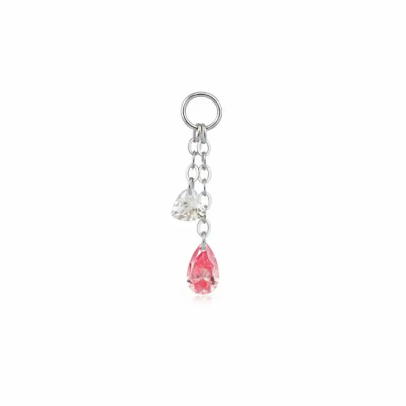 A high-resolution studio photograph of the Pink Pear White Heart Charm from LTM Jewels. This 18K solid gold charm features a unique kinetic design with a laser-drilled 0.10ct white heart-cut diamond paired with a swaying 0.20ct pink pear-shaped lab-grown diamond. The image captures the crystalline purity of the D-E color heart and the delicate rose hues of the pink pear, showcasing the VVS-VS clarity and master craftsmanship of the AU750 gold setting.