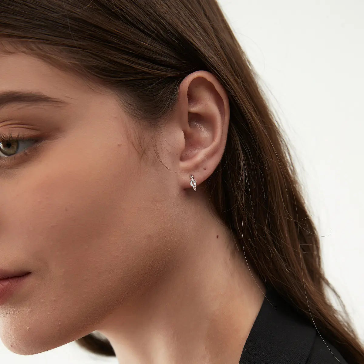 Macro close-up of the Kite Threaded Dangle Stud handcrafted in solid 18K gold. The floating kite-cut lab-grown diamond creates sharp directional reflections, geometric architectural brilliance, and refined contemporary fine jewelry craftsmanship.