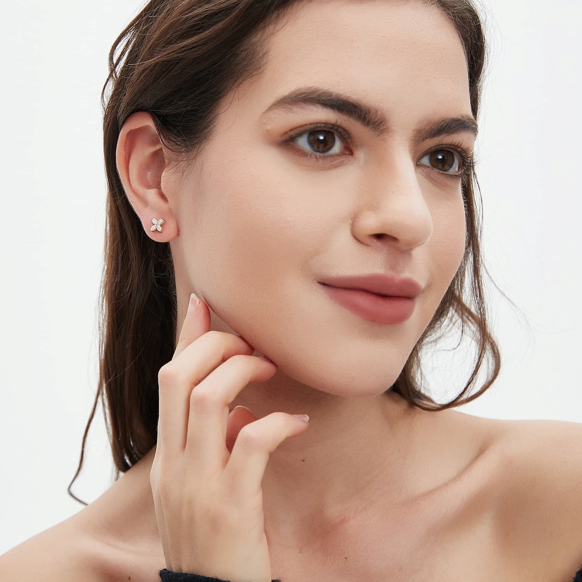 Female model wearing clover diamond stud earrings styled with a minimal outfit, showing how the earrings complement an everyday elegant look.