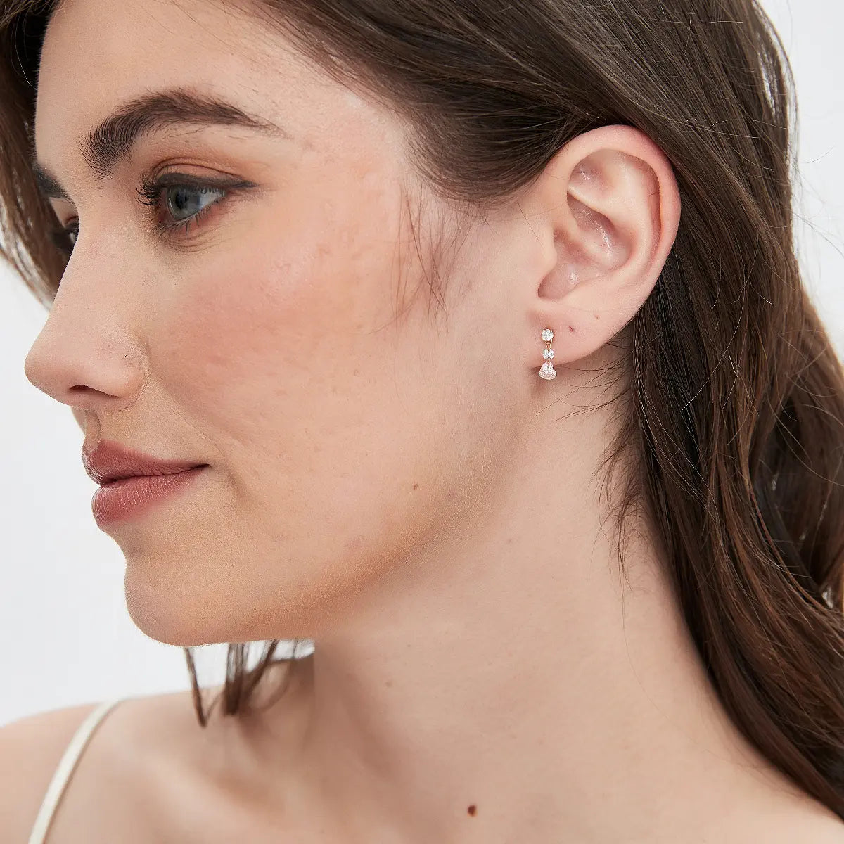 Pink Heart Floating Diamond Stud worn on the ear featuring a suspended pink heart-shaped lab-grown diamond framed by floating white round diamonds. The lightweight floating structure creates elegant movement, exceptional brilliance, and contemporary luxury curated ear styling.