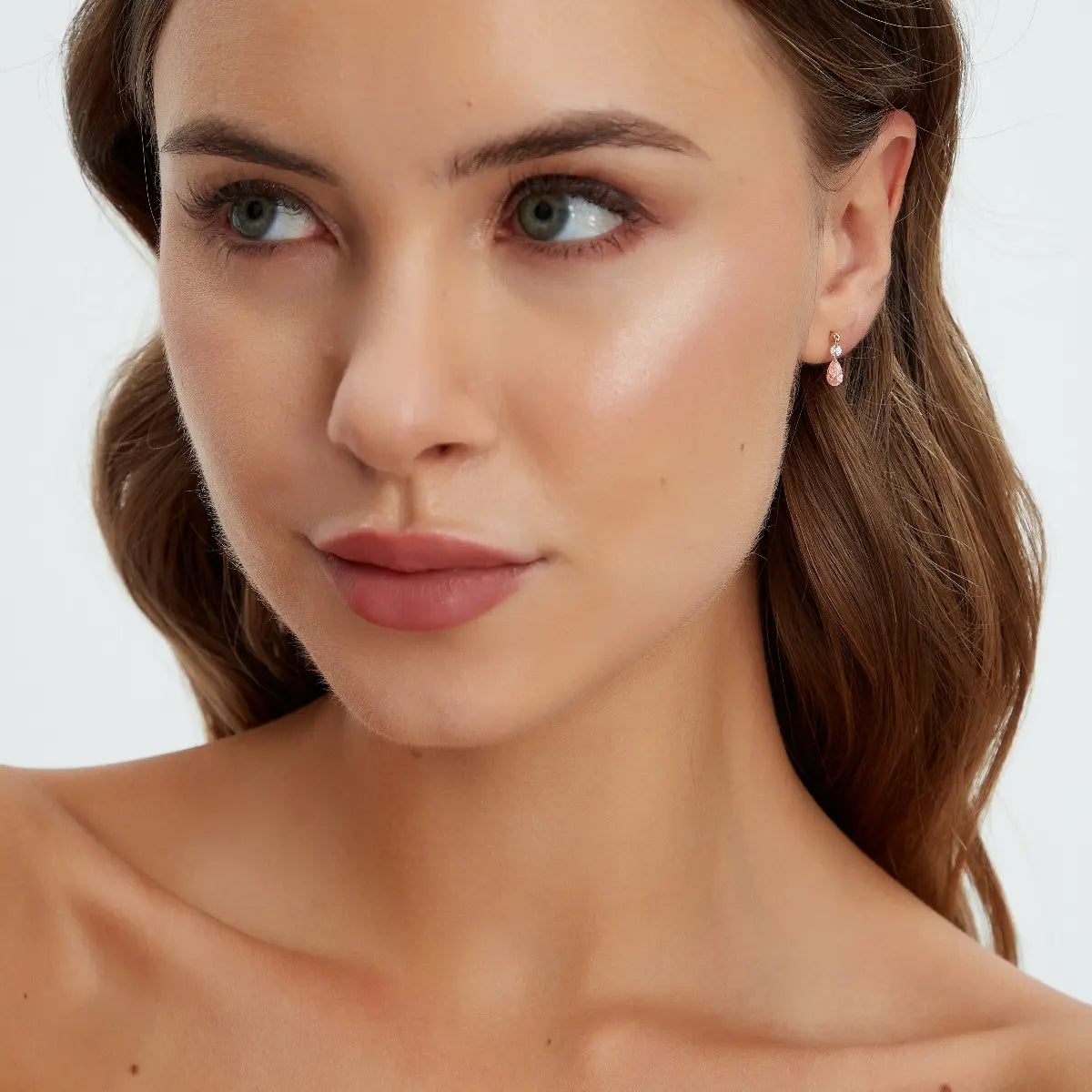 Model wearing Pink Pear and Round Floating Lab Diamond Stud Earrings in 18K solid gold by LTM & CO.™, styled with romantic color and modern elegance