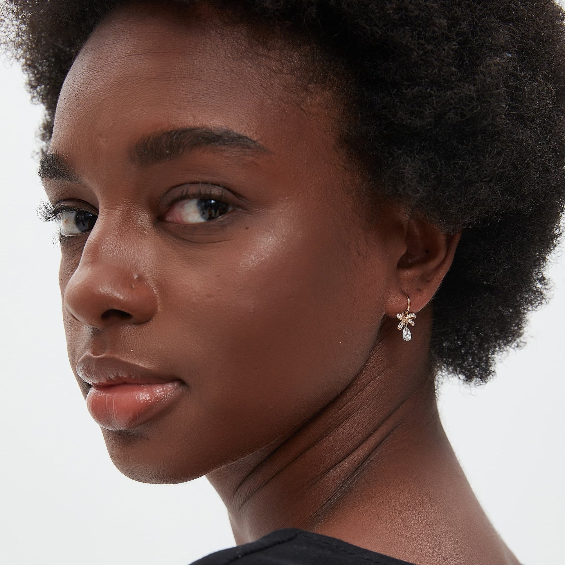 Model wearing butterfly bow pear drop diamond earring charm