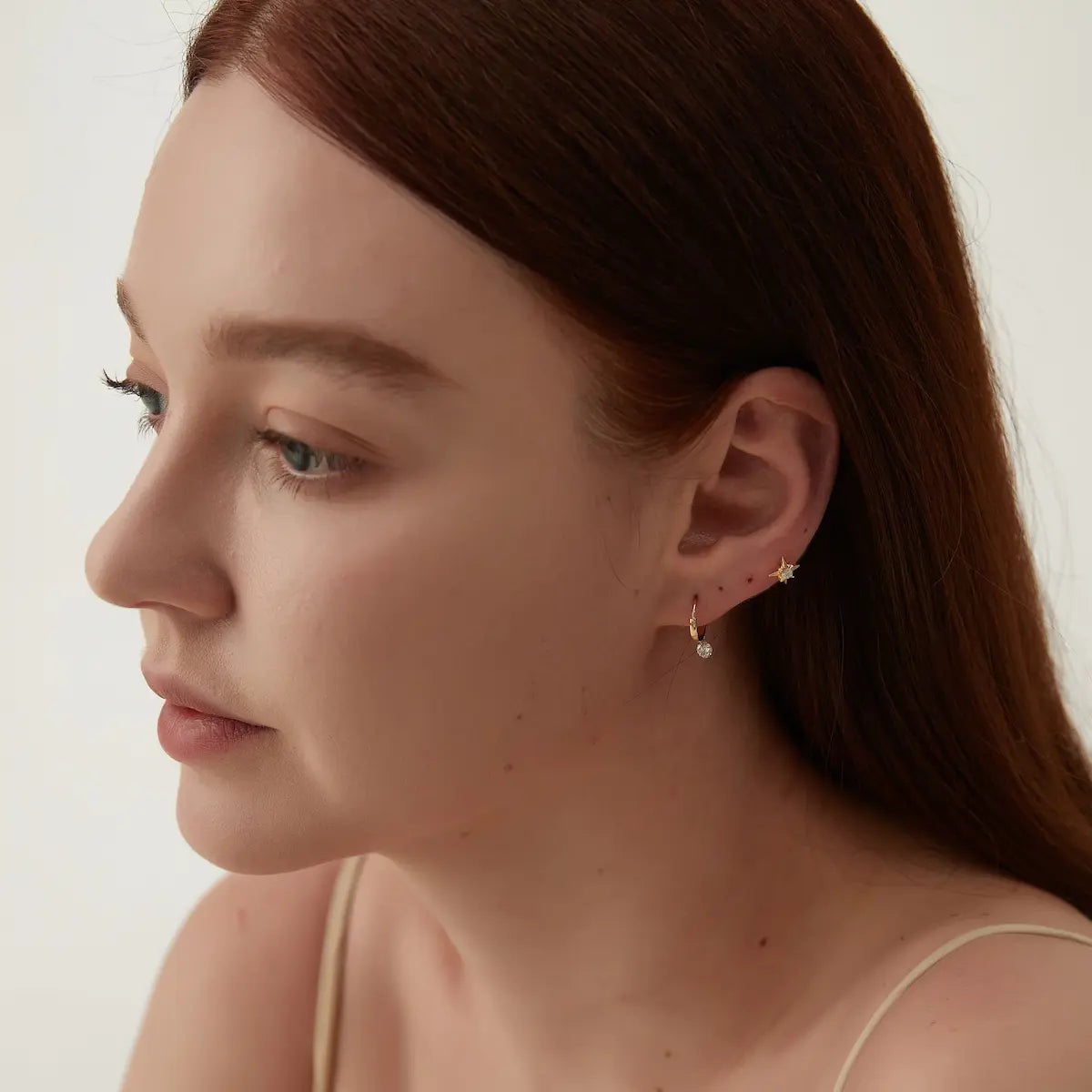 Round Diamond Dangle Hoop worn on the ear featuring a suspended floating 0.2ct round lab-grown diamond and polished 18K gold hoop. The lightweight fluid silhouette creates elegant movement and contemporary curated ear styling with timeless minimalist luxury.