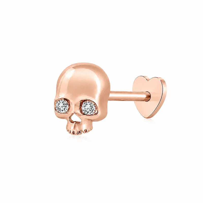 Memento-Mori-Main	A professional high-resolution studio photograph of the Diamond Skull Threaded Stud from the LTM Jewels Memento Mori collection. This 18K solid gold stud is meticulously sculpted with anatomical skull details and accented by a 0.02ct natural round brilliant diamond of VS1 clarity and E color. The image showcases the high-polish AU750 gold finish and the secure threaded screw back design against a clean background, highlighting the blend of rebellion and refinement.