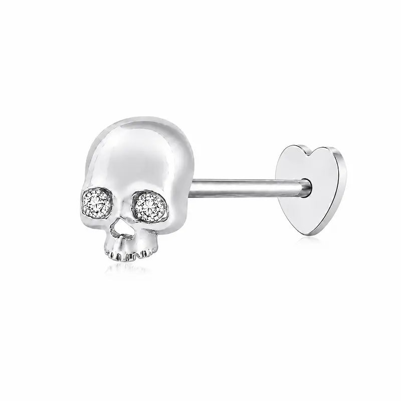 Memento-Mori-Main	A professional high-resolution studio photograph of the Diamond Skull Threaded Stud from the LTM Jewels Memento Mori collection. This 18K solid gold stud is meticulously sculpted with anatomical skull details and accented by a 0.02ct natural round brilliant diamond of VS1 clarity and E color. The image showcases the high-polish AU750 gold finish and the secure threaded screw back design against a clean background, highlighting the blend of rebellion and refinement.