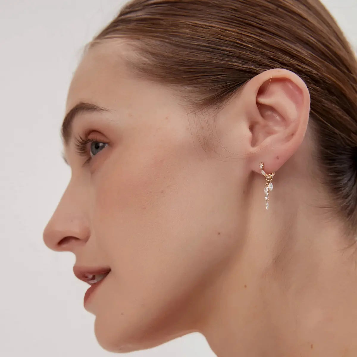 The Marquise Bloom Diamond Charm styled on a 18K gold hoop earring. This shot demonstrates how the charm dangles gracefully, catching light with a rhythmic shimmer. A perfect example of LTM & CO.™'s modular jewelry design, allowing for personalized, architectural ear stacks with a touch of whimsical elegance.