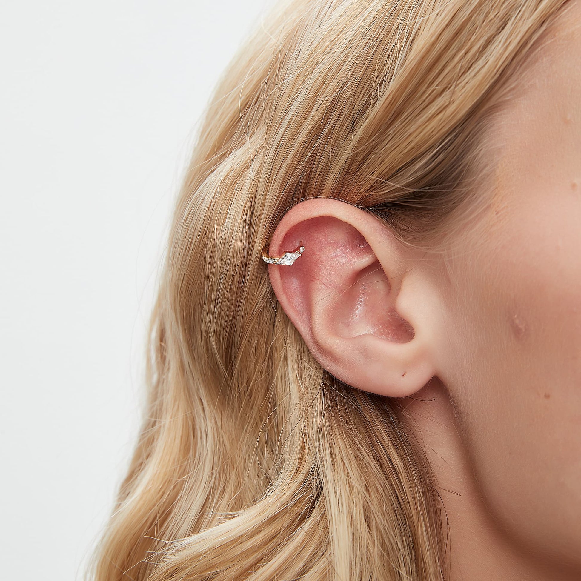 A technical side profile view of the Lozenge Pavé Hoop. This image highlights the structural integrity of the 18K solid gold AU750 construction and the seamless integrated hinge closure engineered for a secure 24/7 permanent fit. The side perspective showcases the 9mm inner diameter and the slim, comfortable profile of the pavé-set diamonds against the geometric frame. The consistent high-polish finish and the alignment of the 0.303ctw diamonds are clearly visible, emphasizing quality.