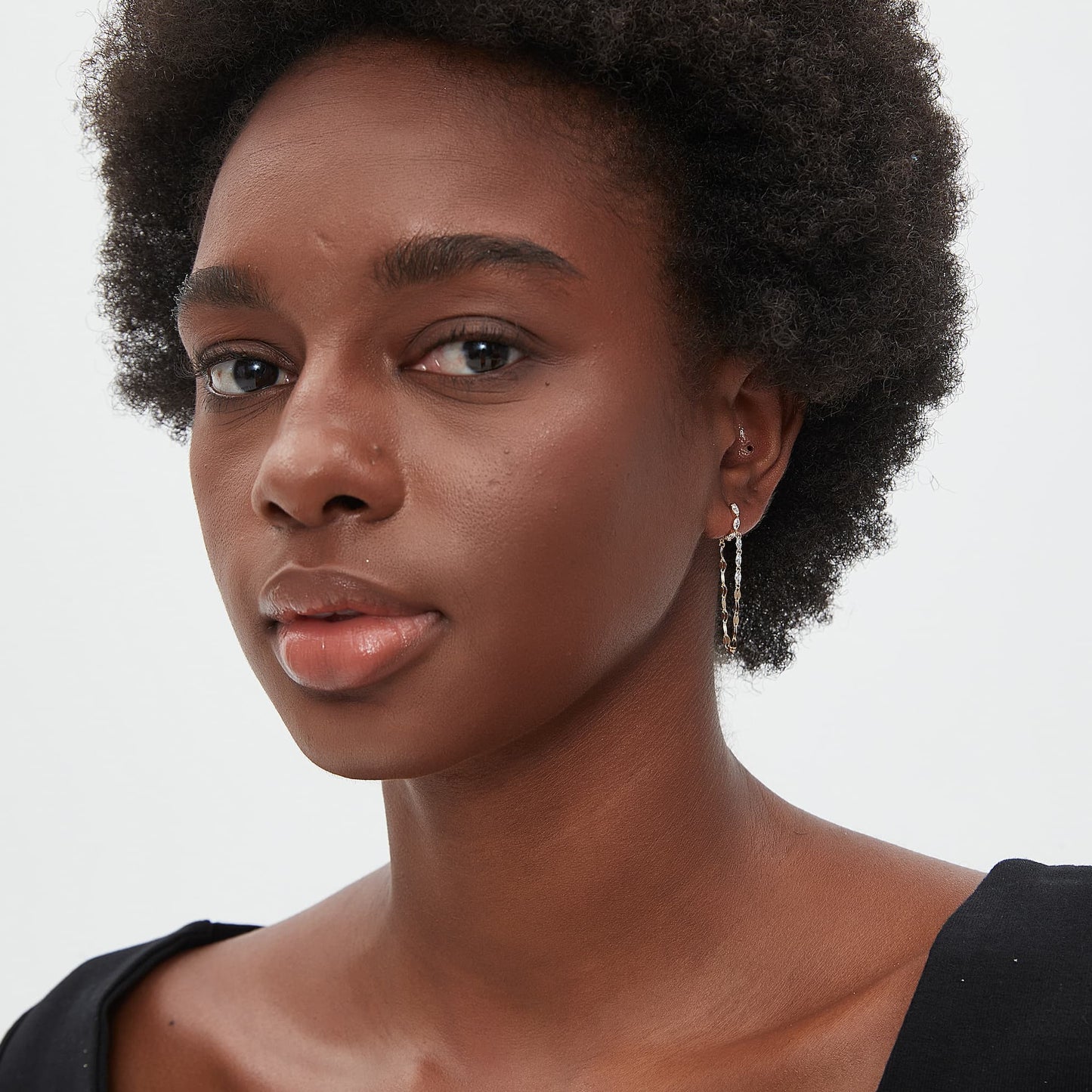 Model wearing The Geometric Sway marquise chain drop hoop in a luxury 18K gold ear stack