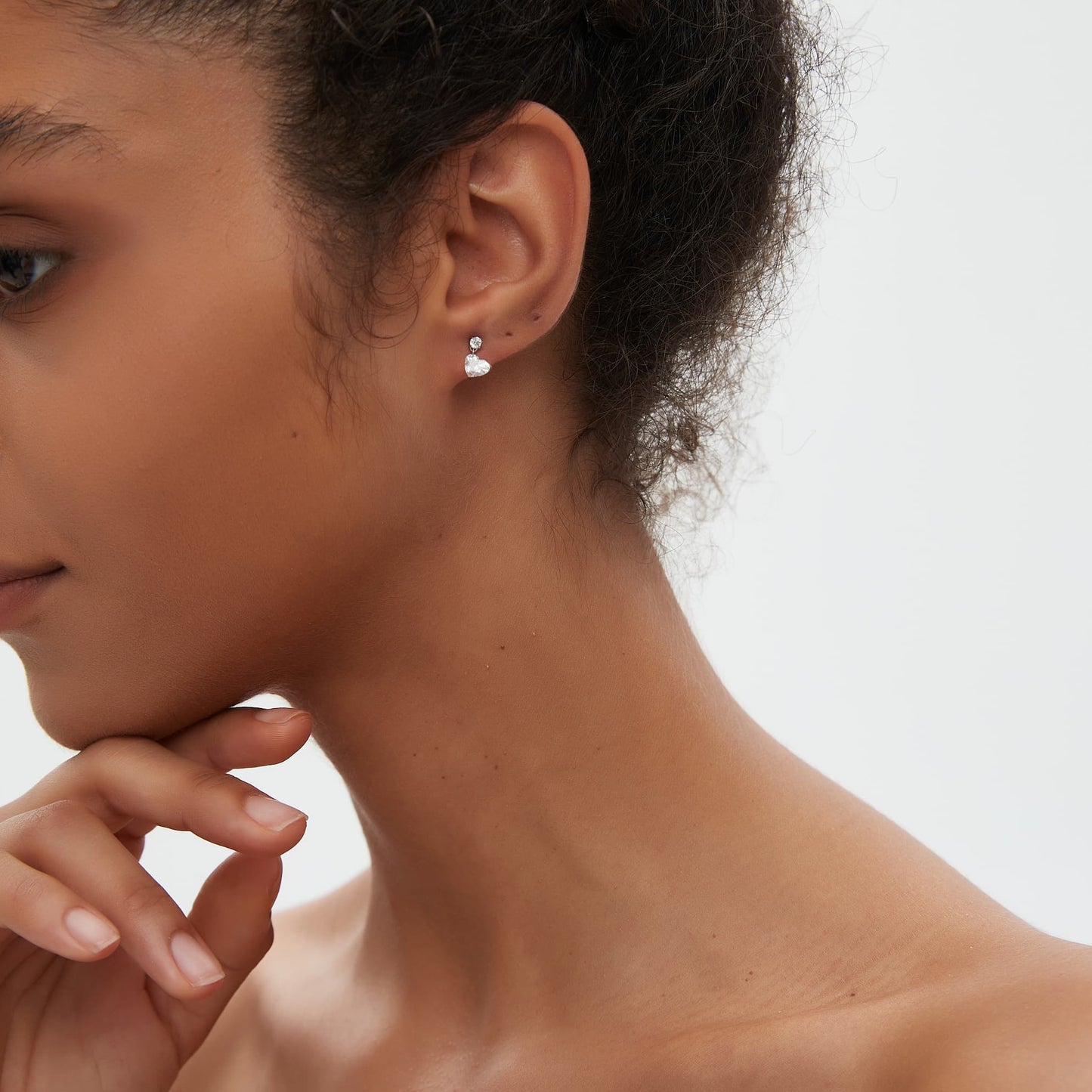 Heart-cut diamond threaded stud earring in 18K gold worn on ear