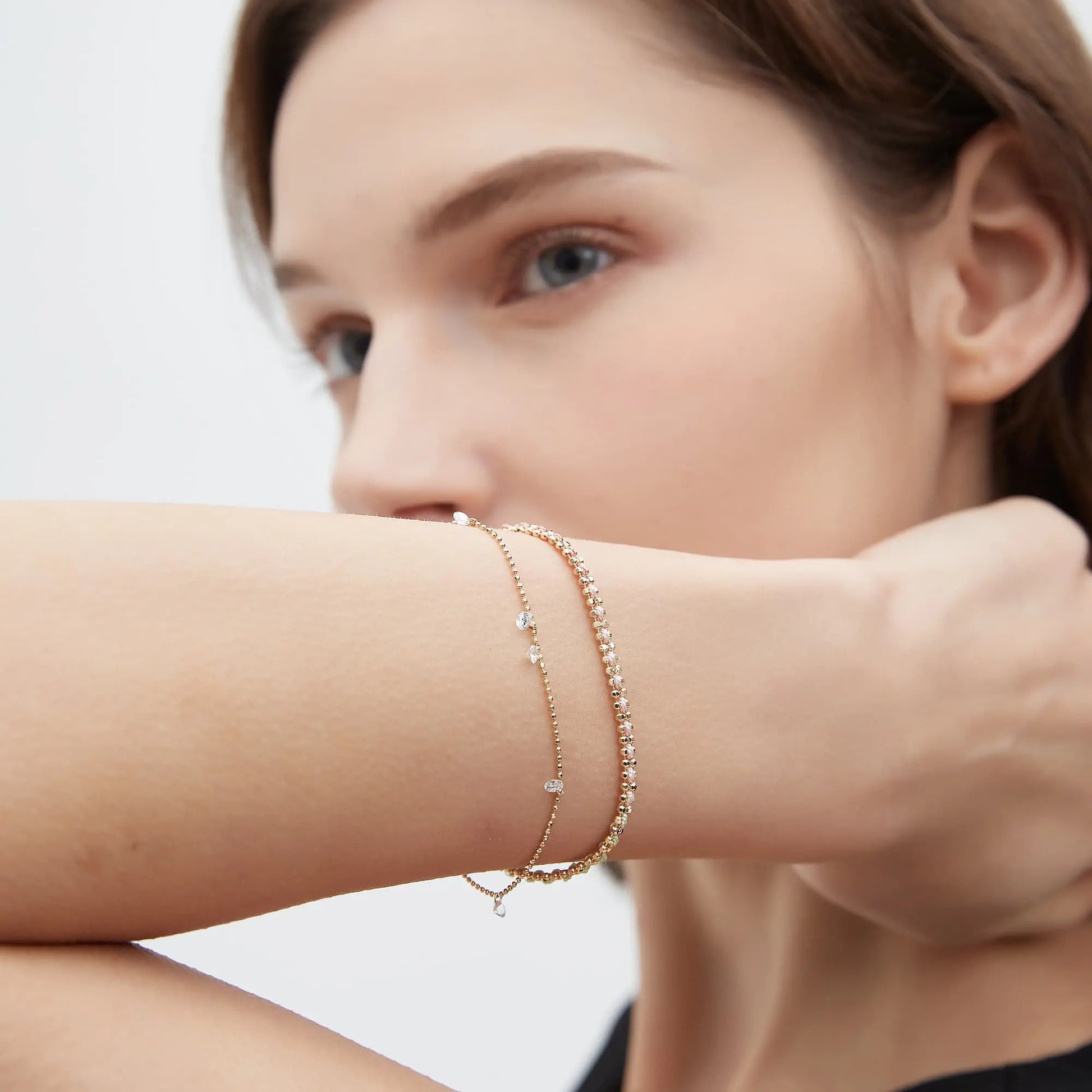 Floating Diamond Rope Bracelet worn on the wrist featuring five suspended round lab-grown diamonds and a delicate woven gold rope chain. The lightweight fluid silhouette creates luminous movement and sophisticated minimalist elegance for layered luxury bracelet styling.
