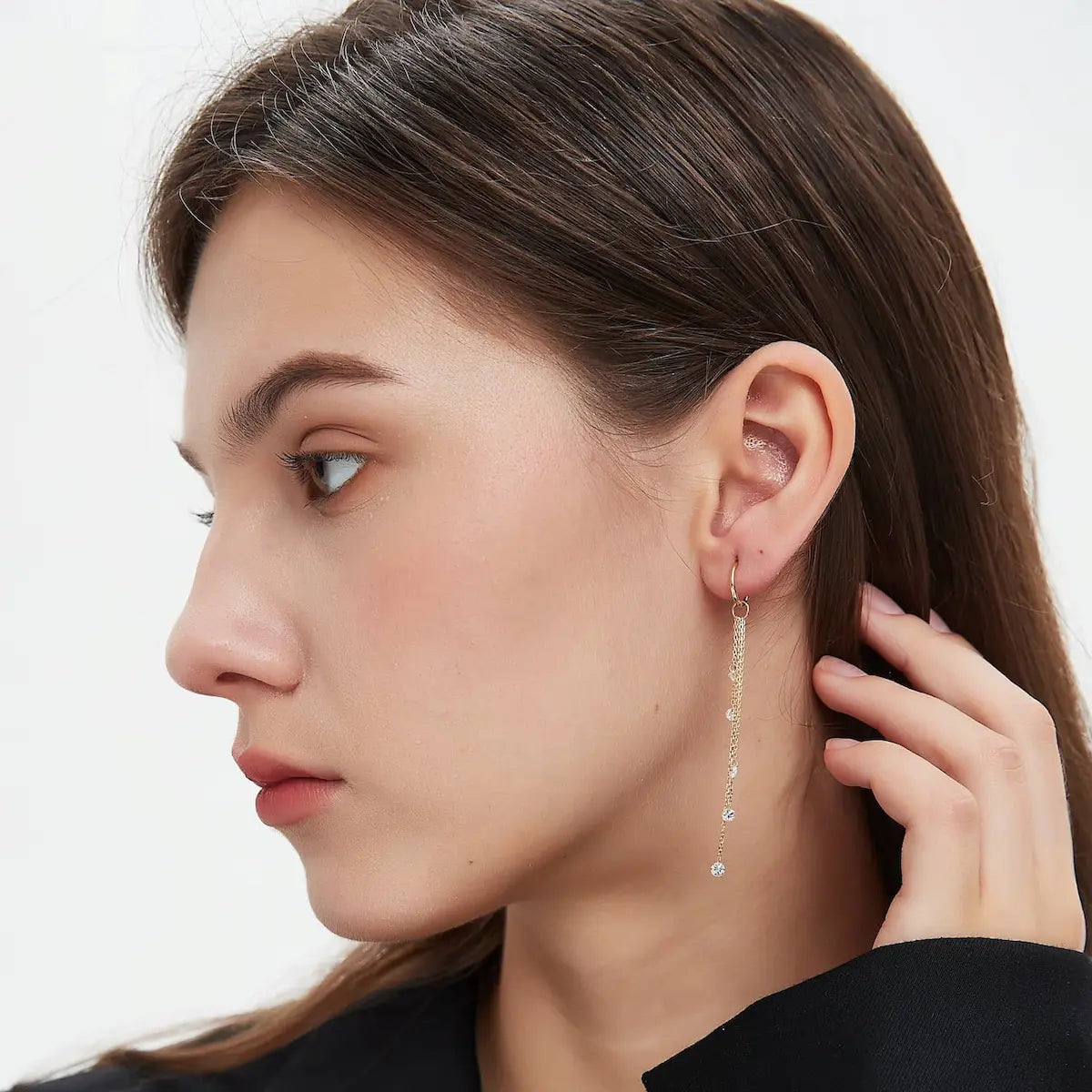 A fashion editorial photograph featuring the Marquise Linear Waterfall Charm by LTM Jewels. The model is seen wearing the charm, illustrating its role as a cinematic heirloom and sophisticated statement piece. The vertical arrangement of 0.25ctw marquise diamonds sparkles brilliantly, complementing an elegant high-end aesthetic. This image captures the 'Celestial Drift' philosophy, showing how the piece adds an effortless luxury and fluid rhythm to a high-fashion look and luxury collection.