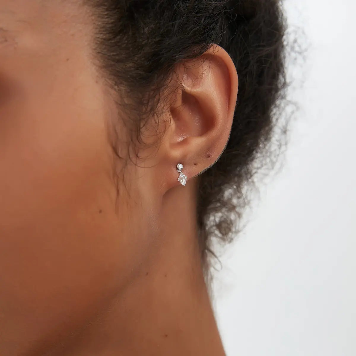 Macro close-up of the Lozenge Dangle Threaded Stud handcrafted in solid 18K gold. The suspended floating lozenge-cut and round lab-grown diamonds create multidimensional brilliance, geometric architectural movement, and refined contemporary fine jewelry craftsmanship.