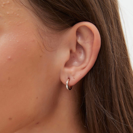 On-ear styling of a luxury minimalist ear stack featuring baguette hoops