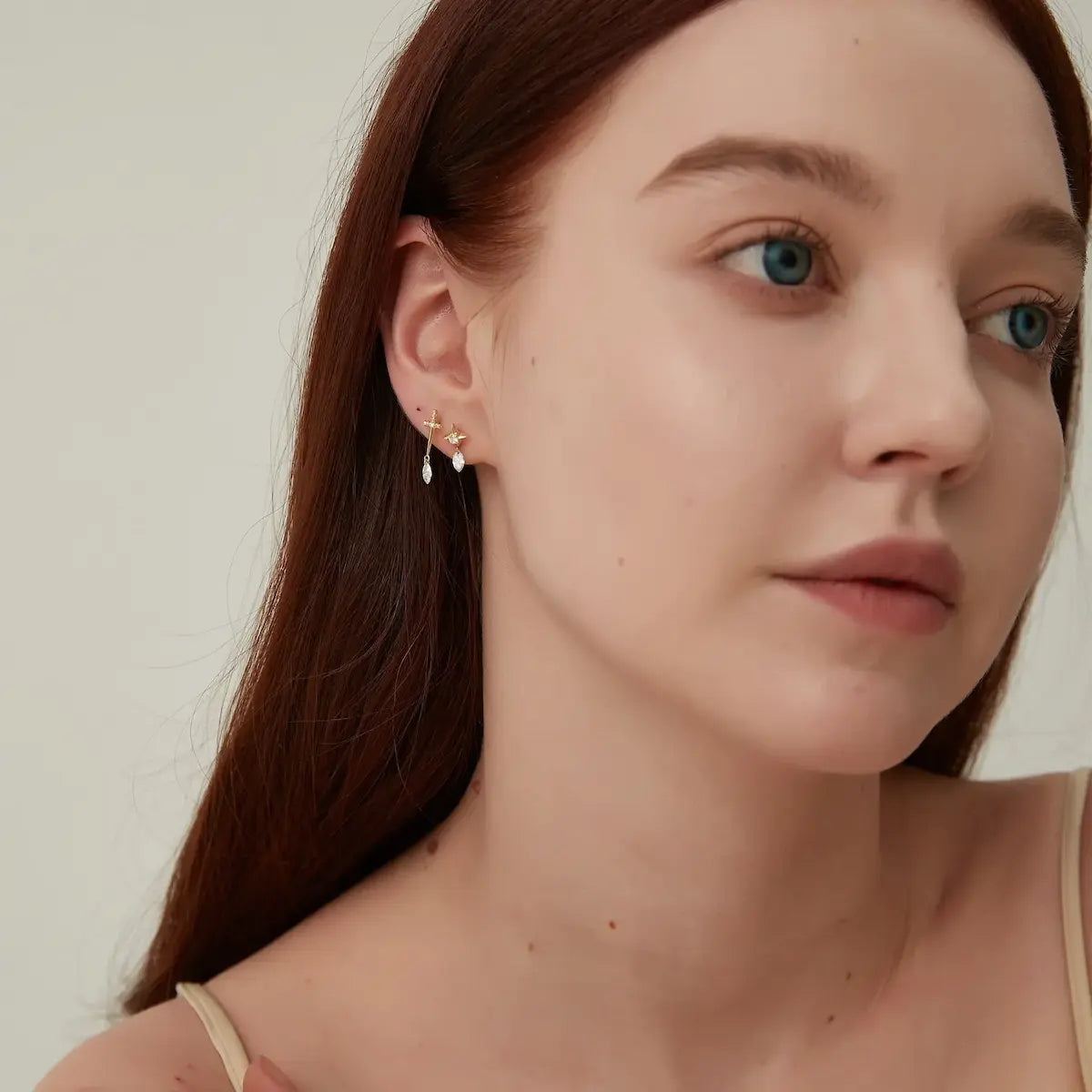 Editorial shot of a model wearing the LTM & CO.™ Architectural Rhythm star dangle earring. The geometric star and floating marquise diamond reflect a bold, contemporary aesthetic. This piece embodies sustainable luxury and innovative design, perfect for the modern individual who appreciates architectural beauty and ethical fine jewelry.