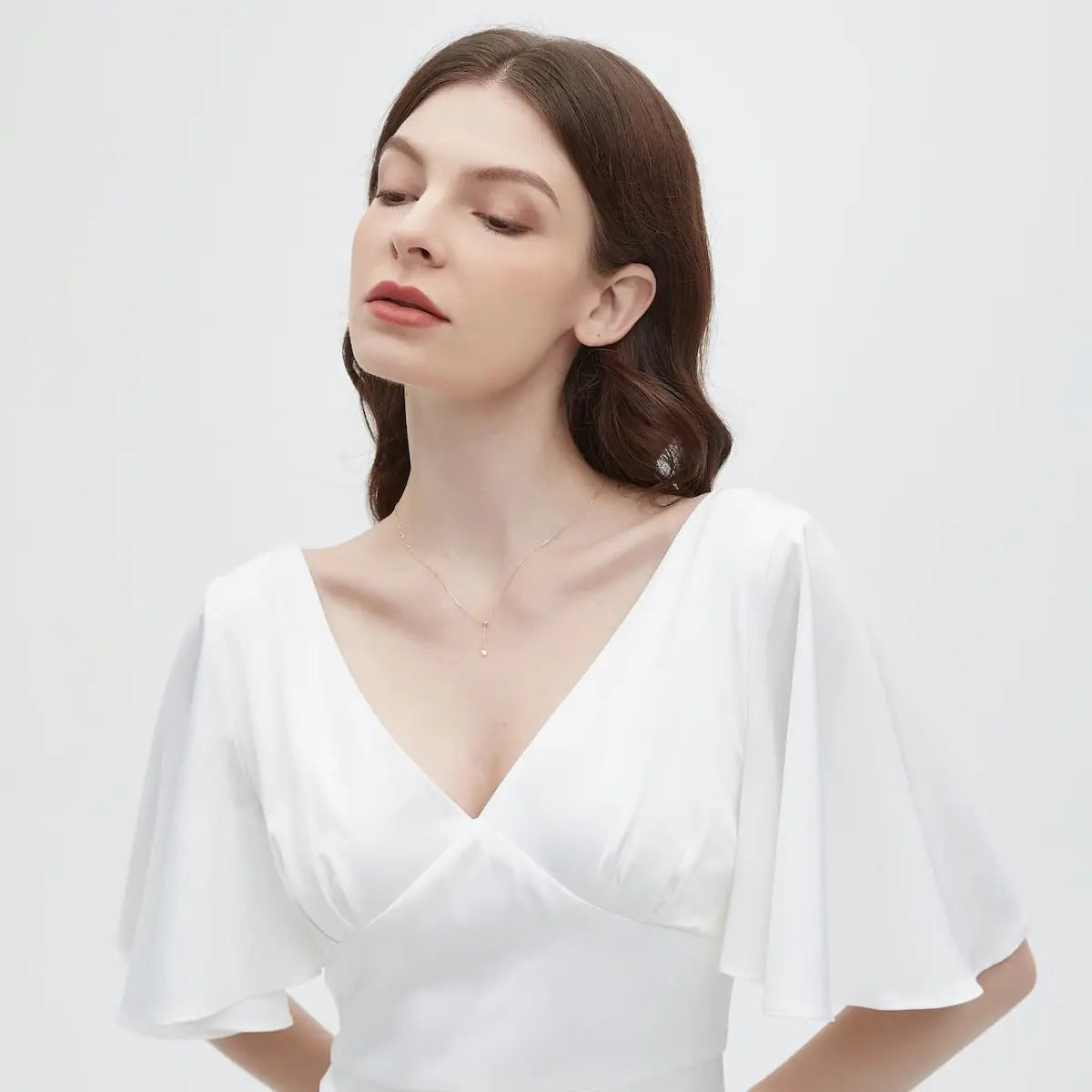 A fashion editorial photograph featuring the Adjustable Round Diamond Necklace by LTM Jewels. The model is seen wearing the piece, highlighting its role as a cinematic heirloom and modern statement of luxury. The 0.2ct diamond sparkles brilliantly as it sits elegantly on the model, showcasing the necklace's fluid silhouette and adjustable length from 40cm to 45cm. This image captures the atmospheric grace of the piece, illustrating its sophisticated presence in a high-end luxury context.
