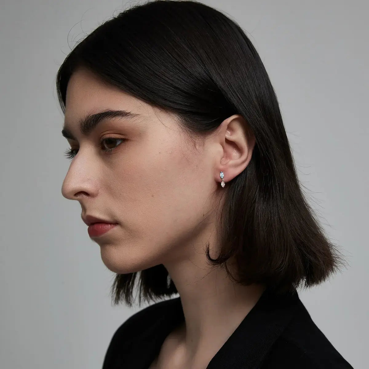 Model wearing the Blue and Pink Marquise Dangle Stud from the Chromatic Reverie collection. The floating blue and pink marquise diamonds create cinematic brilliance, fluid movement, and high-fashion editorial luxury jewelry styling inspired by modern heirloom design.