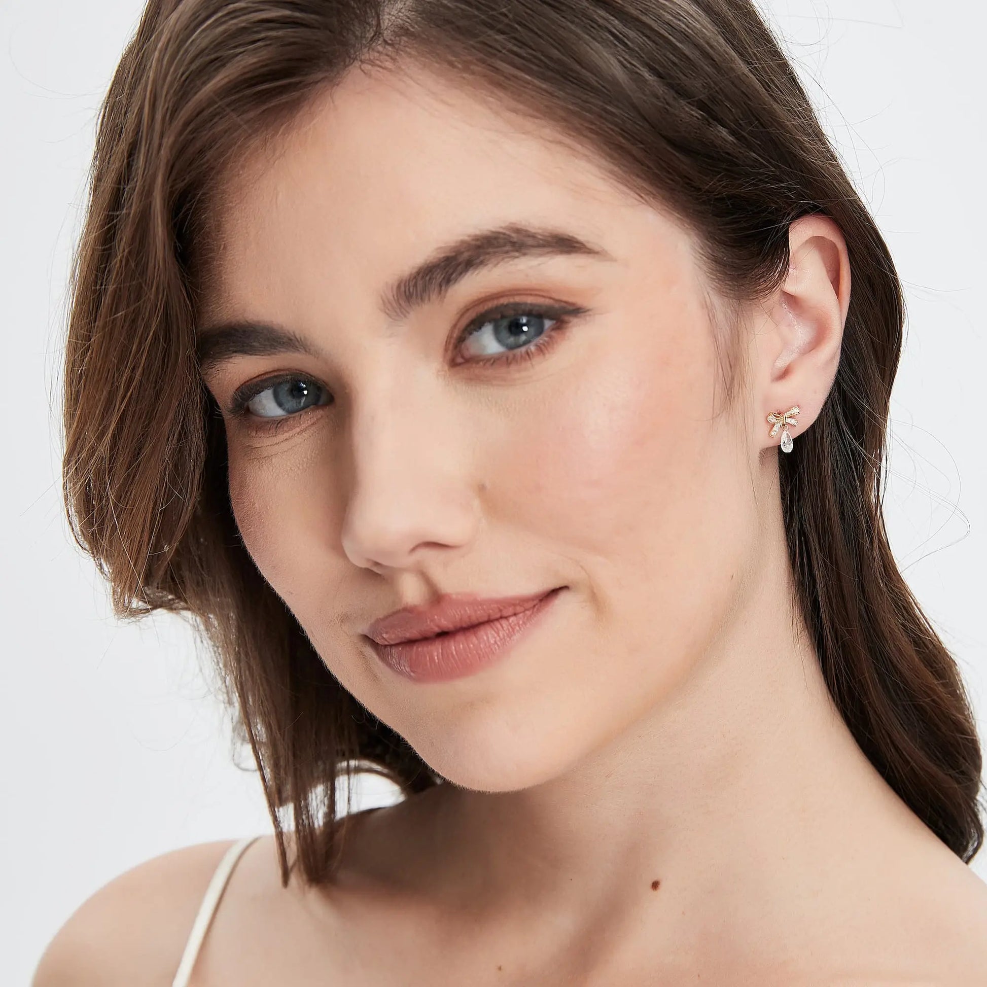 Model wearing Celestial Drift butterfly bow pear diamond dangle stud.
