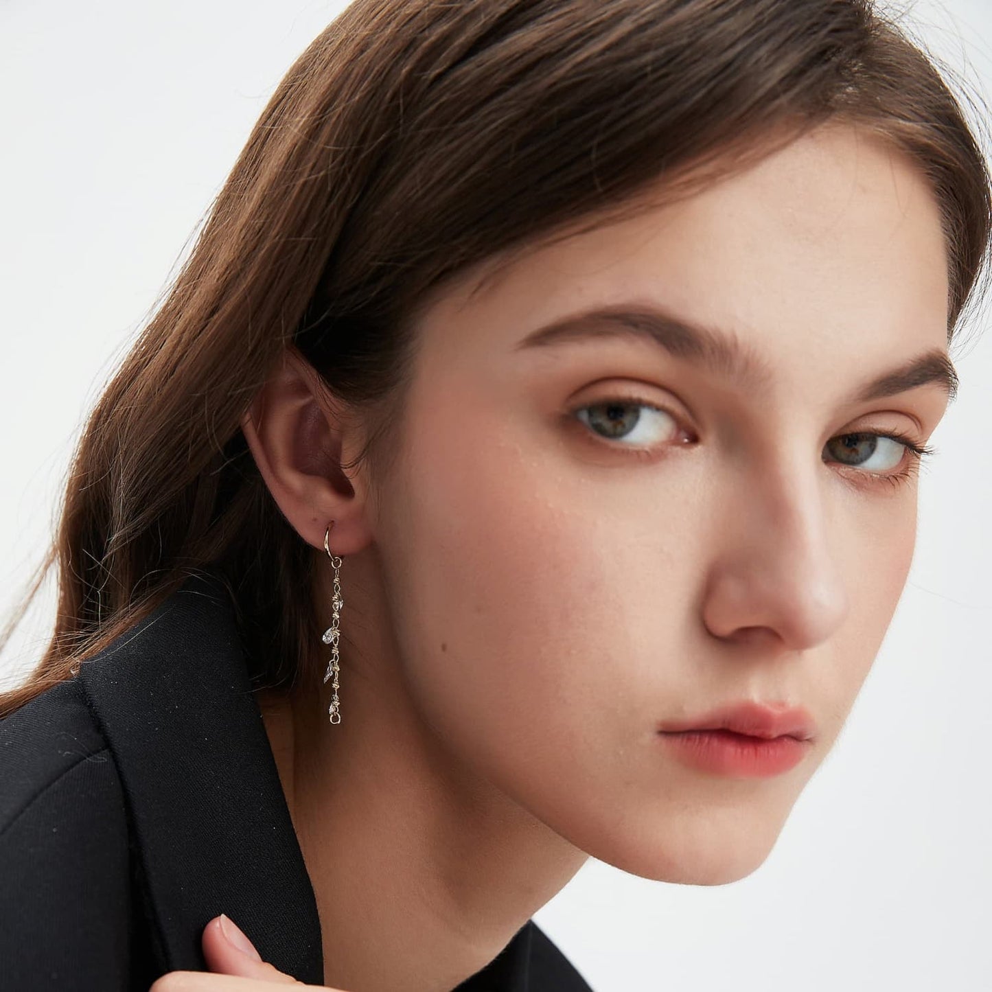 An on-ear image showing the charm looped onto a single gold hoop, creating a refined layered look. Demonstrates the modular dual-attachment feature for personalized ear curation.