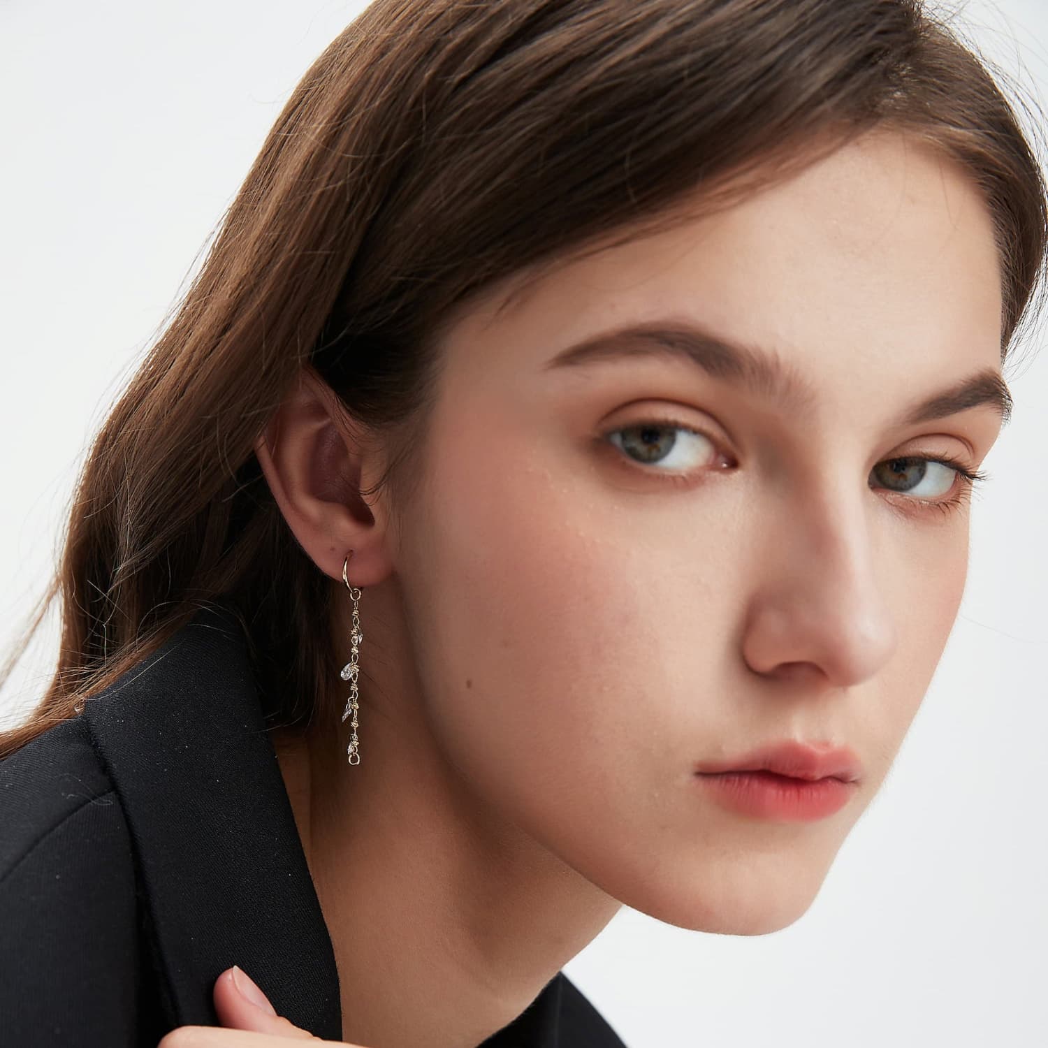 An on-ear image showing the charm looped onto a single gold hoop, creating a refined layered look. Demonstrates the modular dual-attachment feature for personalized ear curation.