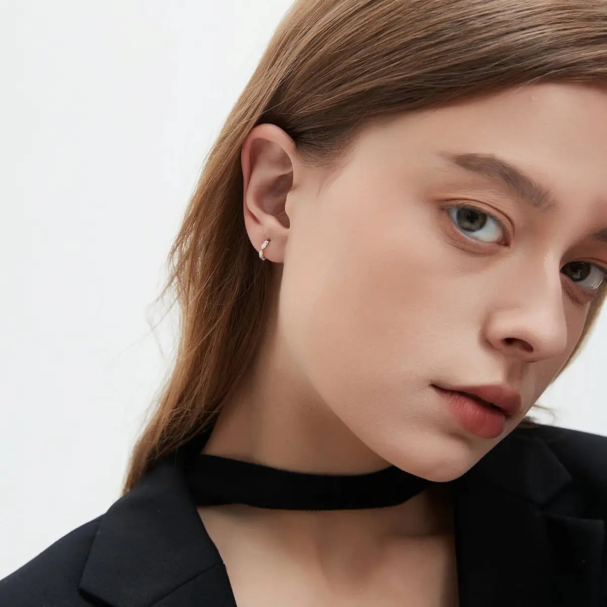 Lifestyle photography of a model wearing the Eternal Radiance marquise row earring, showcasing its radiant glow and sculptural form in natural light. The aesthetic emphasizes a "modern heirloom" theme, proving the piece's suitability for both luxury daily wear and formal gala events. This shot highlights the scale of the 7-stone variant, demonstrating its hypoallergenic solid gold construction and ethical luxury appeal for conscious jewelry collectors.
