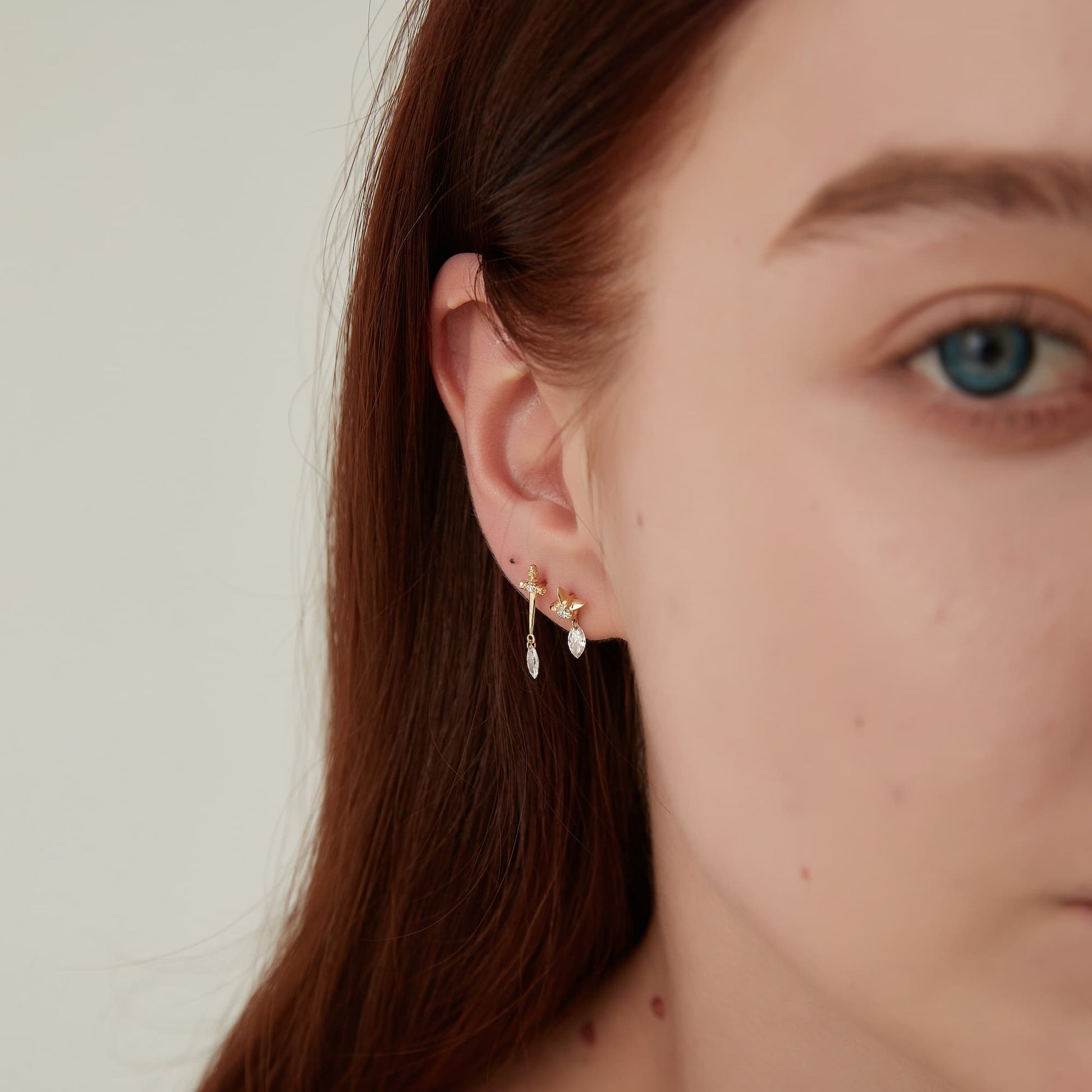 Model wearing Architectural Rhythm marquise star dangle piercing stud.