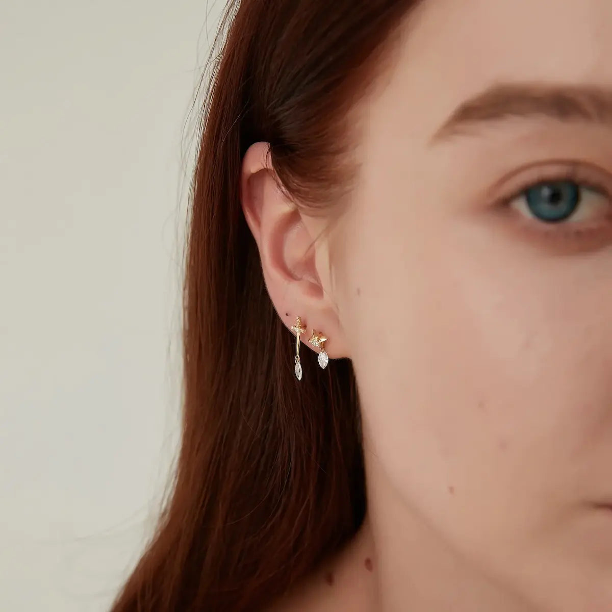 On-ear view of the Star Floating Marquise Diamond Dangle Stud. The 18K gold star sits securely as a threaded stud, while the marquise diamond dangles with rhythmic movement. The floating design creates an ethereal sparkle that catches light from all angles, offering a sophisticated and modern look for any curated ear stack.
