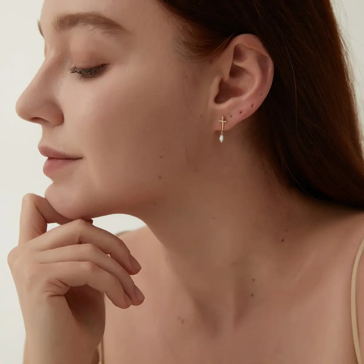 Sword Marquise Dangle Threaded Stud worn on ear in 18K solid gold, showcasing vertical design and marquise diamond movement.