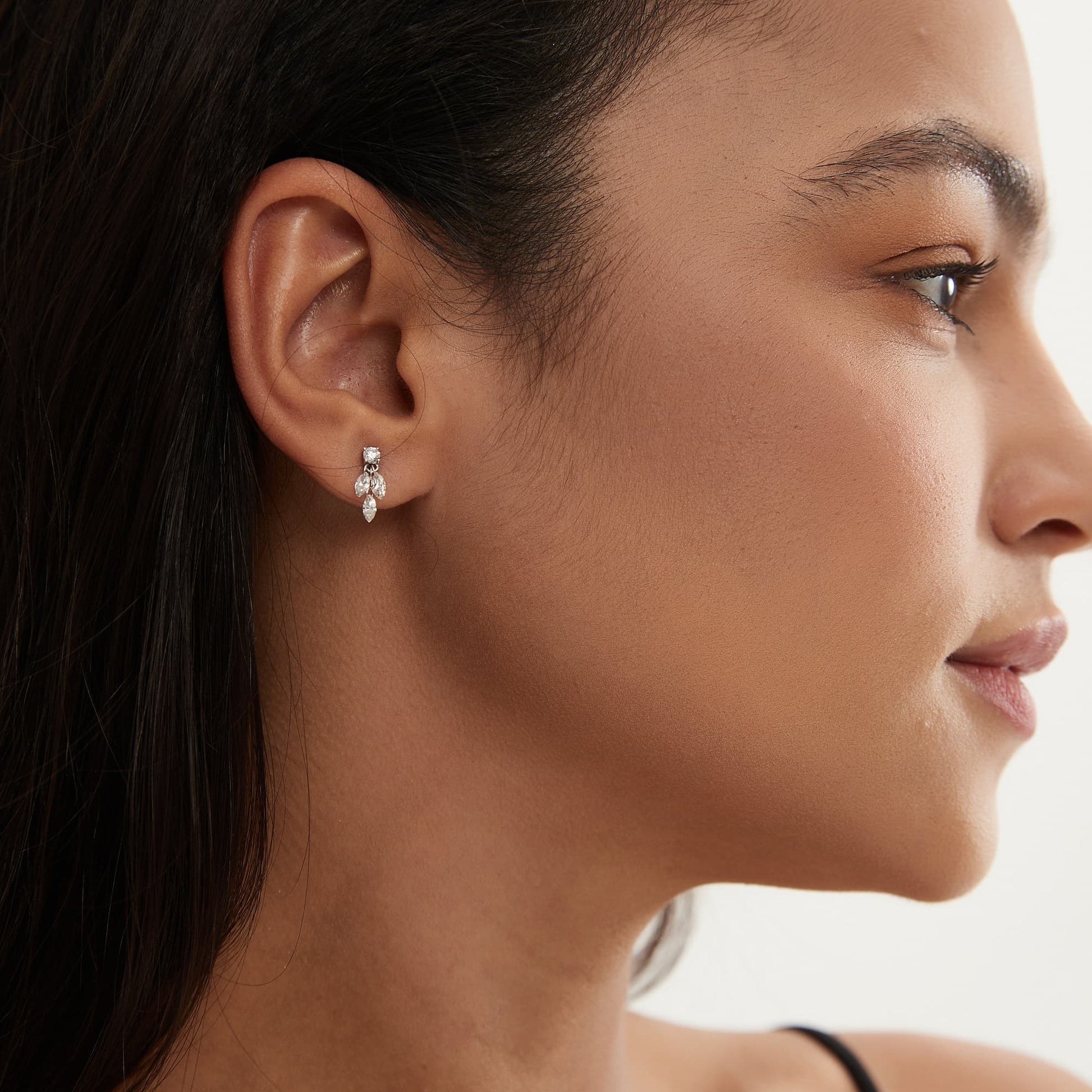 Model wearing Architectural Rhythm marquise triple diamond dangle stud.